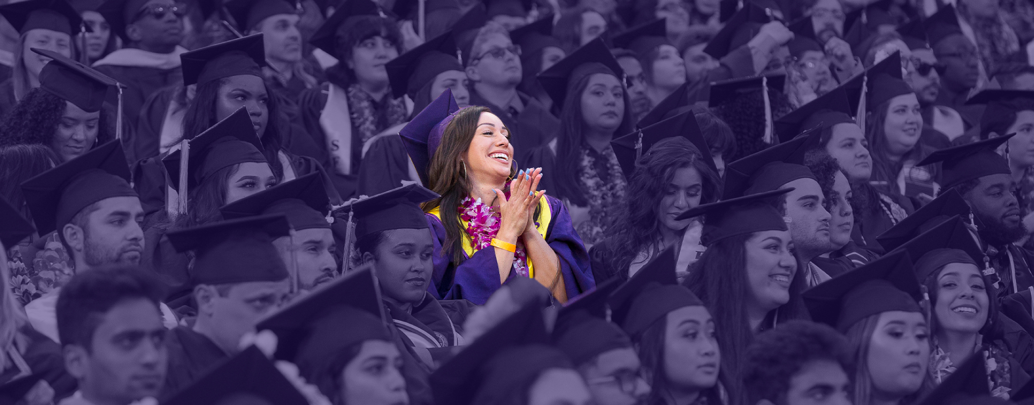 SF State graduate cheers with excitement in a sea of purple regalia