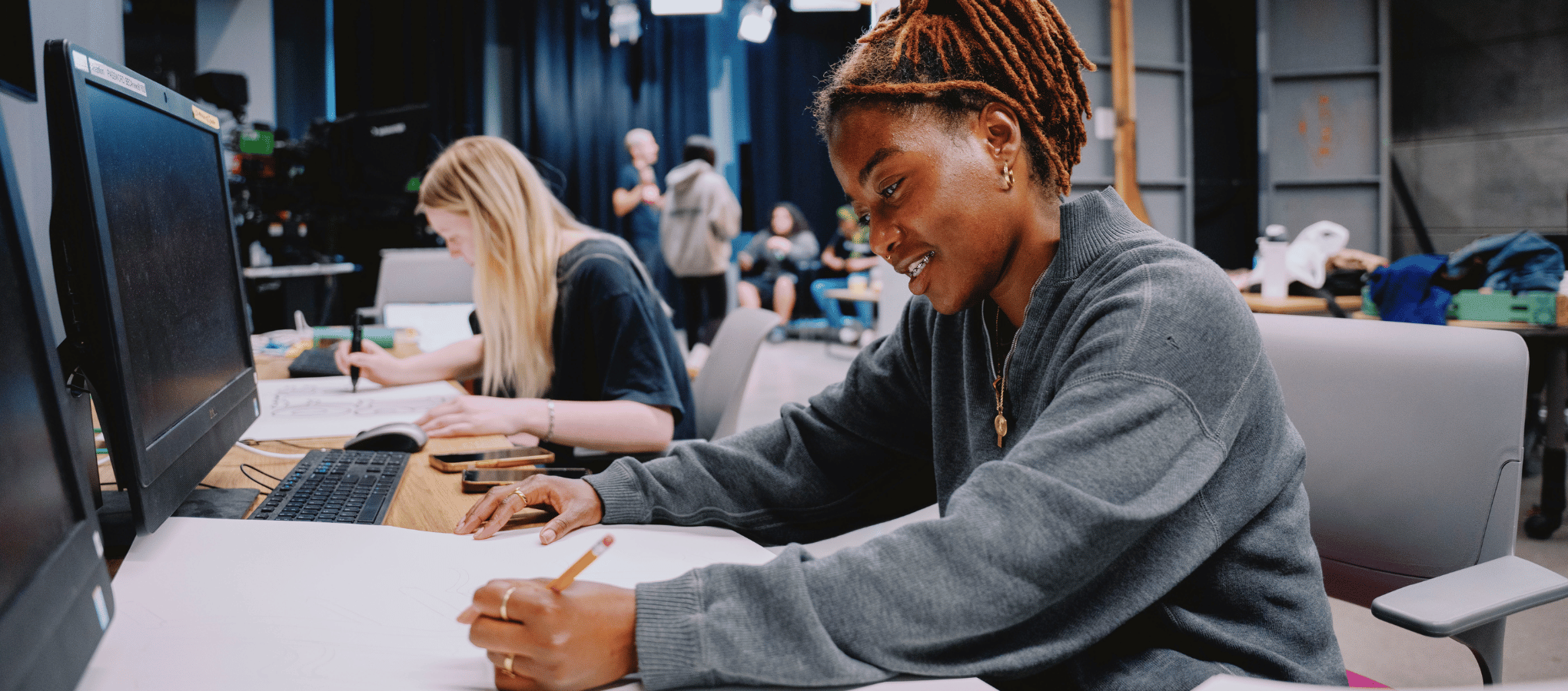 SFSU broadcast student writing down plans in studio