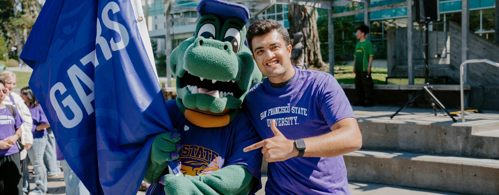 Alli the Gator waving flag with Student at Pinning Ceremony