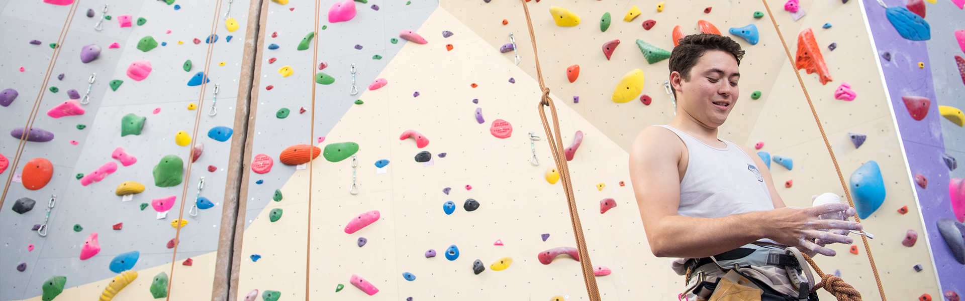 SF State student chalking up their hands to use rock wall