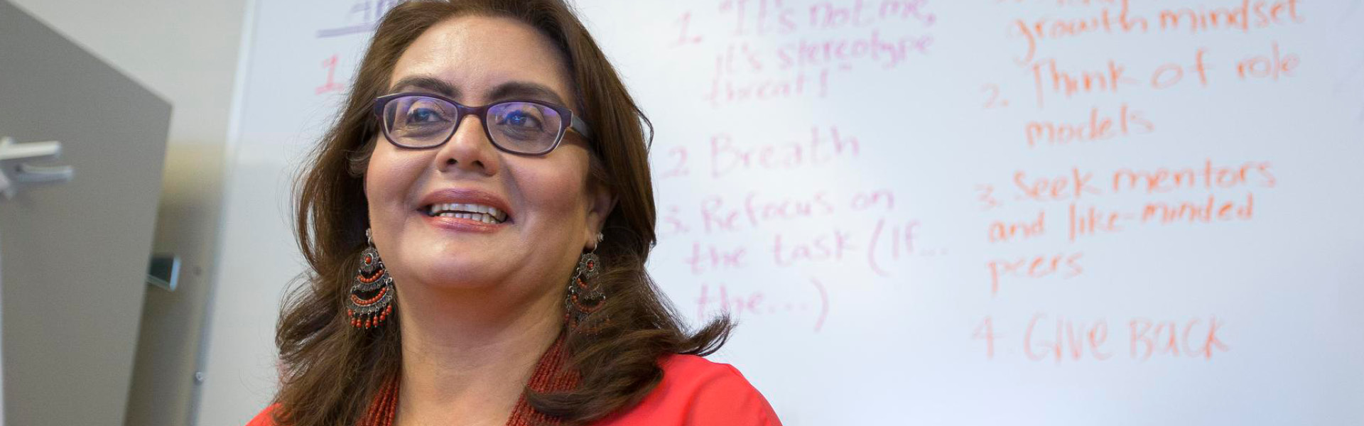 Woman smiling in front of a whiteboard