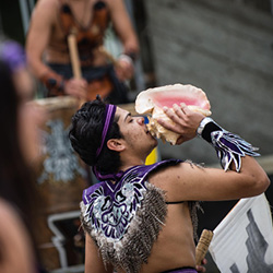 Man in tribal clothing with a sea conch